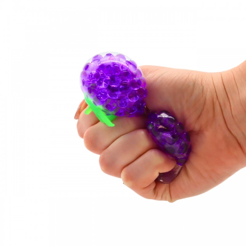 detalle mano apretando juguete antiestrés con forma de uva de textura flexible