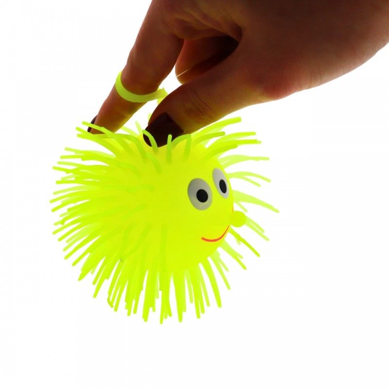 Mano sujetando una Puffer Ball amarilla mediante el anillo elástico.