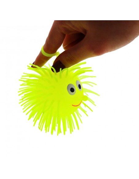 Mano sujetando una Puffer Ball amarilla mediante el anillo elástico.