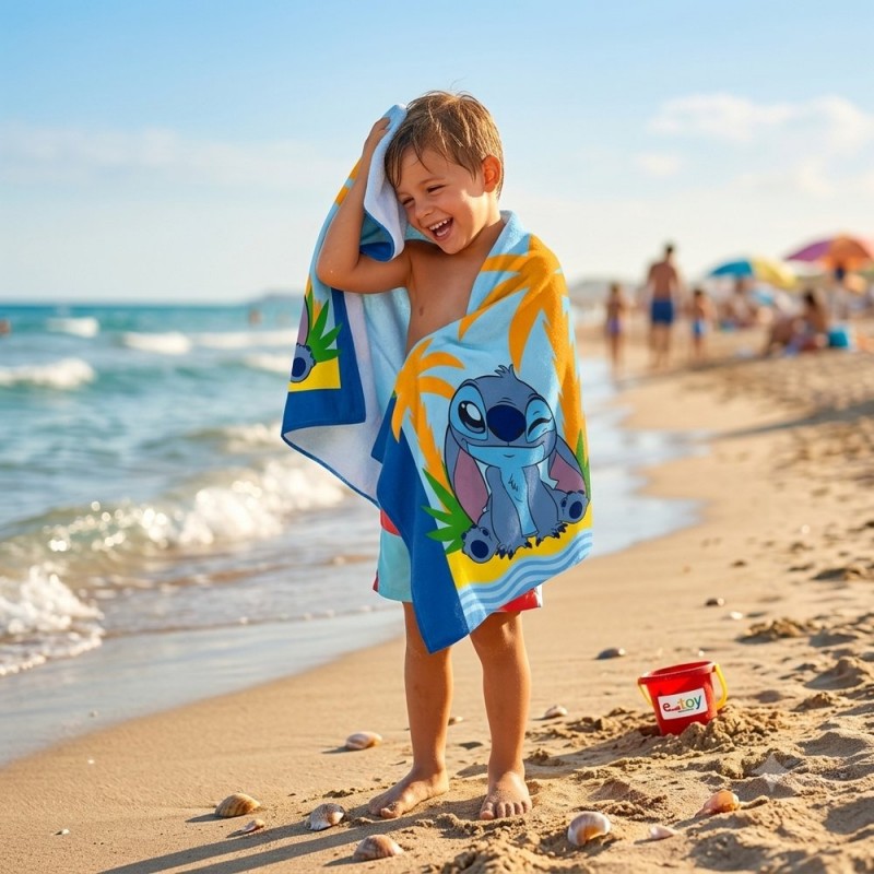 Niño sonriendo en la playa secándose con la toalla de microfibra Stitch de Disney