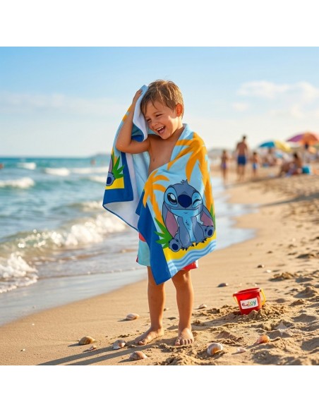 Niño sonriendo en la playa secándose con la toalla de microfibra Stitch de Disney