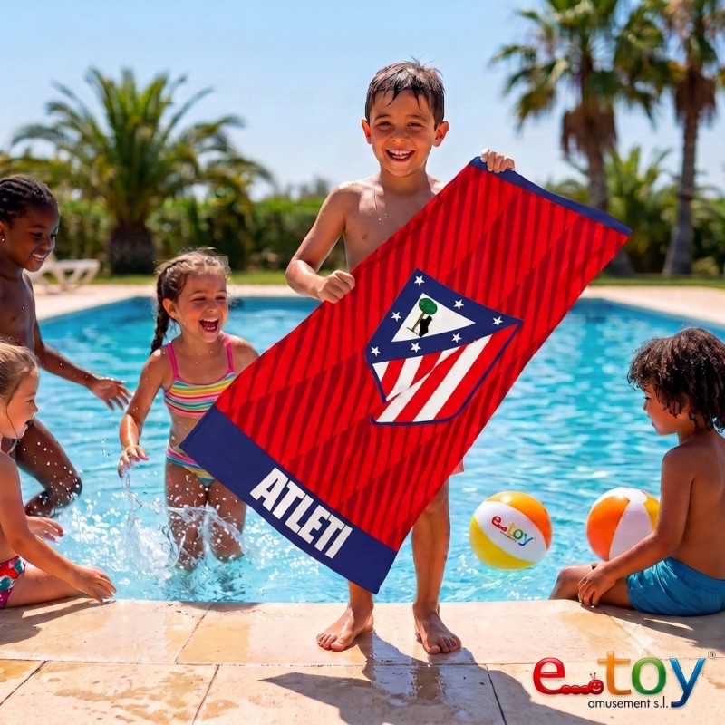 Niño mostrando sonriente la toalla de microfibra del Atlético de Madrid en una piscina