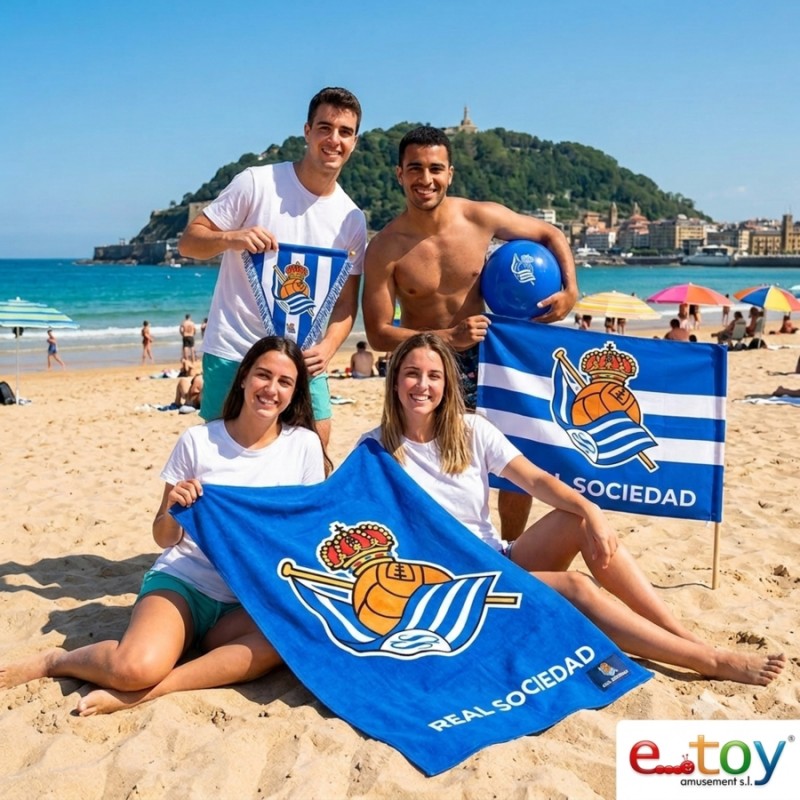 Grupo de aficionados de la Real Sociedad con la toalla oficial de microfibra en la playa de La Concha en San Sebastián