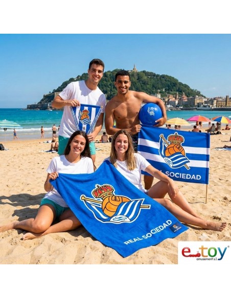 Grupo de aficionados de la Real Sociedad con la toalla oficial de microfibra en la playa de La Concha en San Sebastián
