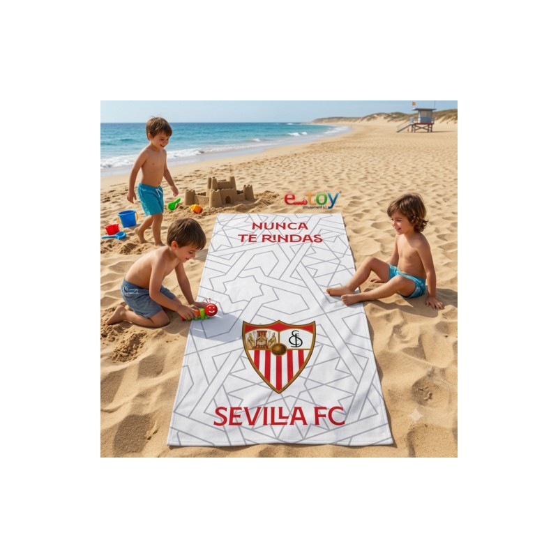 Toalla de playa oficial Sevilla FC con escudo y lema 'Nunca te Rindas', niños jugando en la arena.