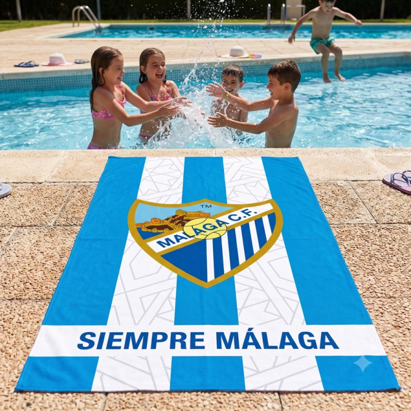 Toalla de microfibra del Málaga CF extendida junto a la piscina con niños jugando