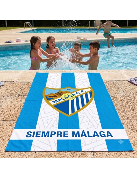 Toalla de microfibra del Málaga CF extendida junto a la piscina con niños jugando