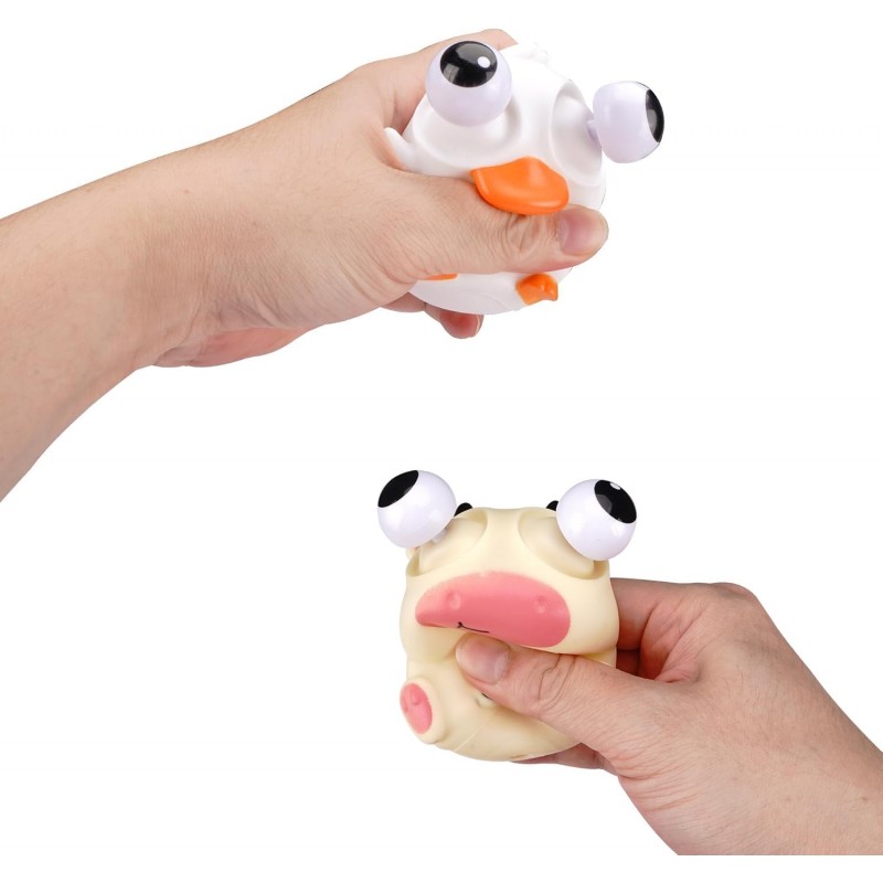 Manos apretando los animales antiestrés de patito y vaca haciendo saltar sus ojos.