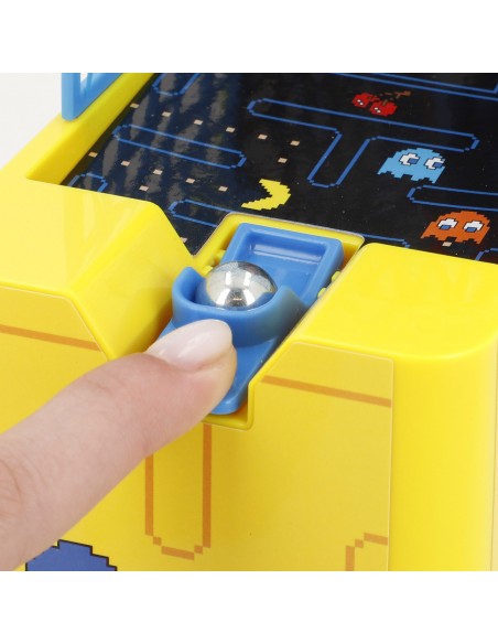 Detalle de primer plano del lanzador manual con bola metálica y gatillo azul del juego de baloncesto de mesa Pac-Man Arcade.