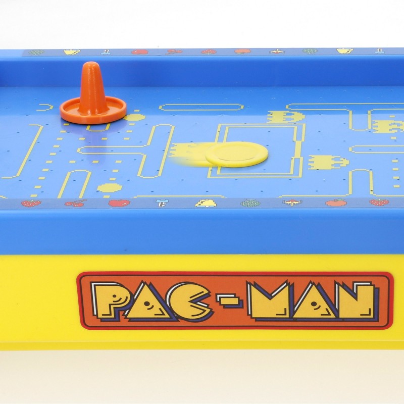 Plano detalle del disco amarillo deslizándose sobre la pista azul del juego de Air Hockey de mesa Pac-Man Mini Arcade.