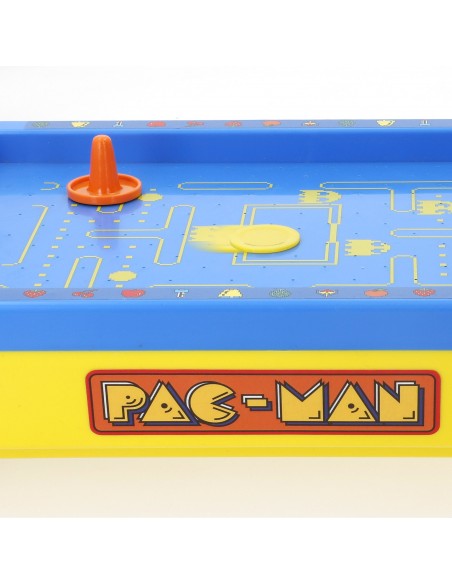 Plano detalle del disco amarillo deslizándose sobre la pista azul del juego de Air Hockey de mesa Pac-Man Mini Arcade.