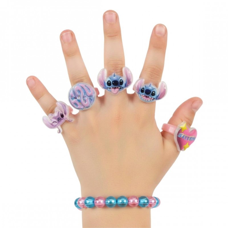 Mano de niña luciendo la pulsera de cuentas y los 5 anillos ajustables de Stitch y Angel.