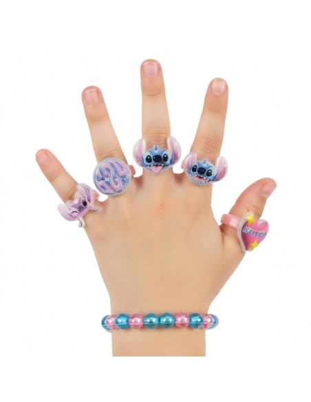 Mano de niña luciendo la pulsera de cuentas y los 5 anillos ajustables de Stitch y Angel.