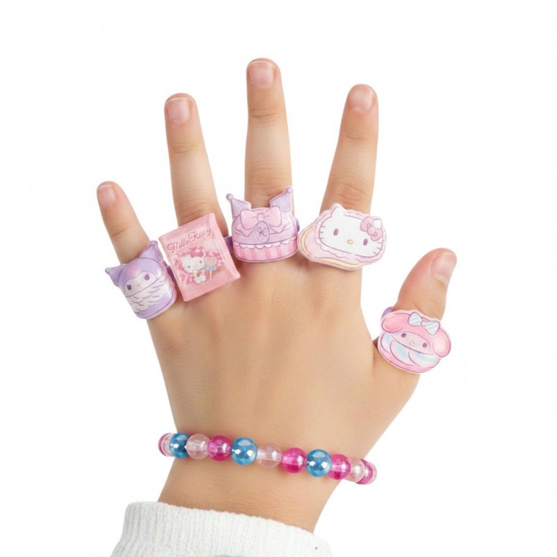 Mano infantil luciendo la pulsera de cuentas y los 5 anillos ajustables de Hello Kitty, Kuromi y My Melody.