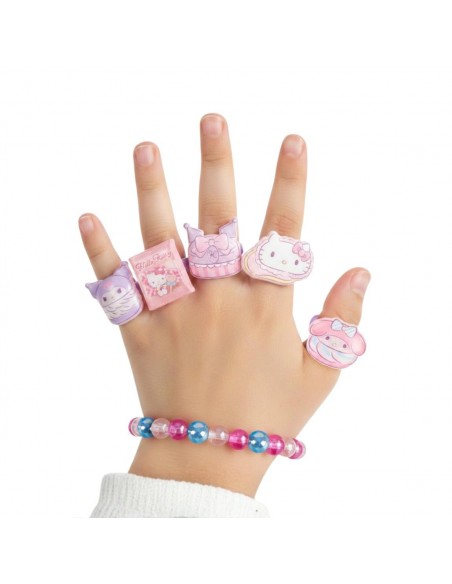 Mano infantil luciendo la pulsera de cuentas y los 5 anillos ajustables de Hello Kitty, Kuromi y My Melody.