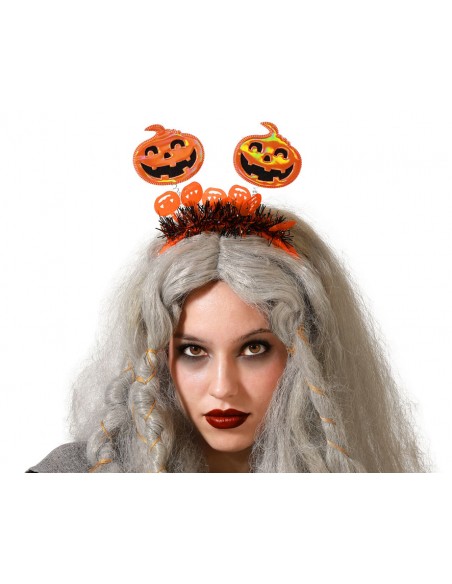 Modelo luciendo una diadema de Halloween con calabazas en muelles y flecos decorativos.