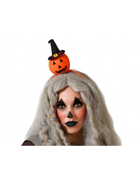 Modelo luciendo una diadema de Halloween con calabaza y sombrero de bruja.